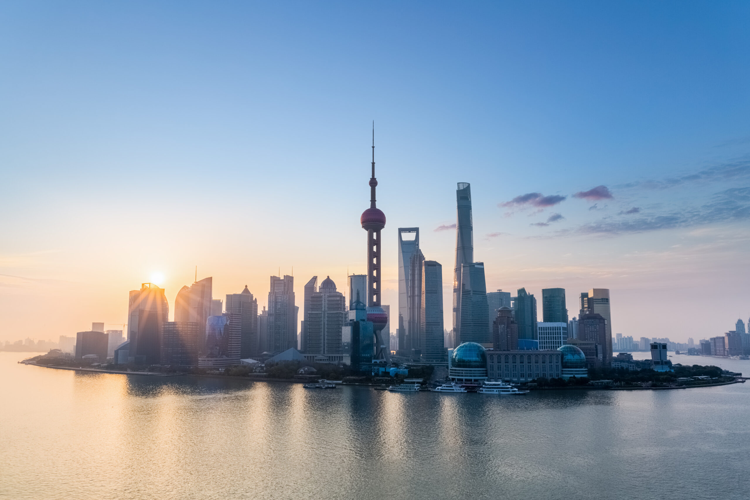Skyline de Pudong, em Shanghai, com a Torre Pérola Oriental e a Torre de Shanghai refletidas no Rio Huangpu ao nascer do sol.
