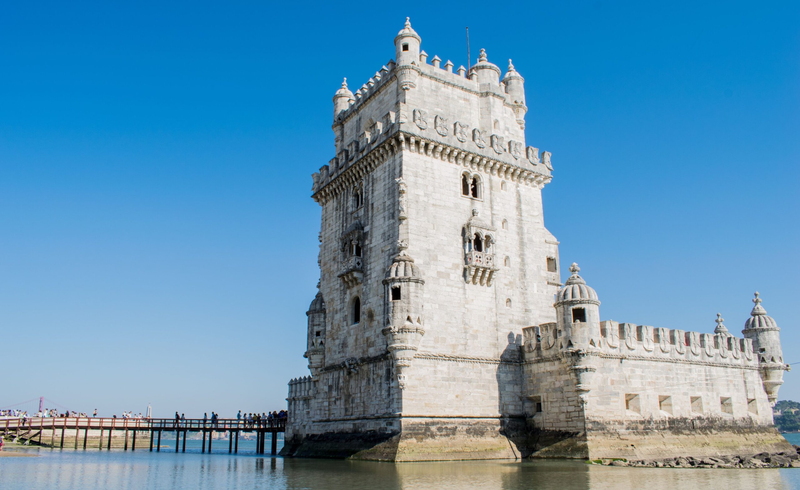Torre de Belém às margens do Rio Tejo em Lisboa, monumento manuelino do século XVI com passarela de acesso sobre a água
