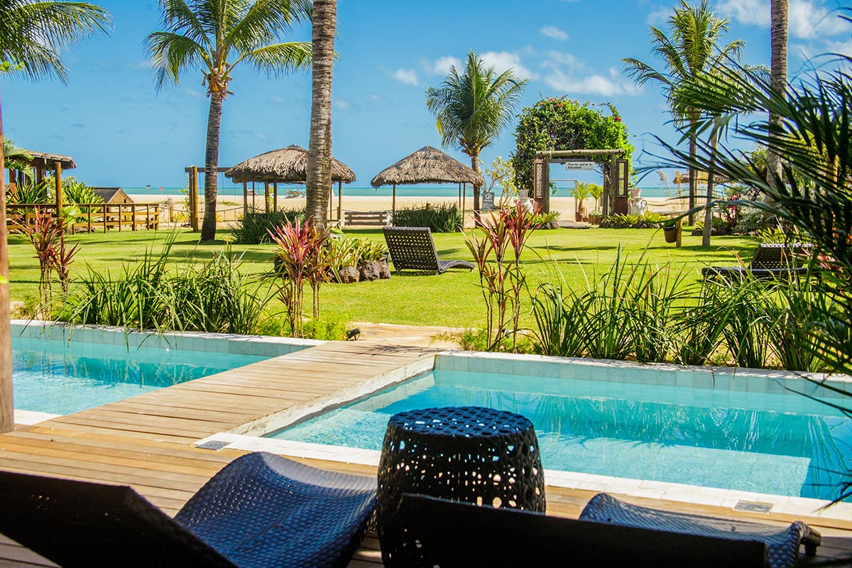 Piscinas cercadas por jardim com vista para o mar na Mi Secreto Pousada & Spa, em São Miguel do Gostoso, Rio Grande do Norte