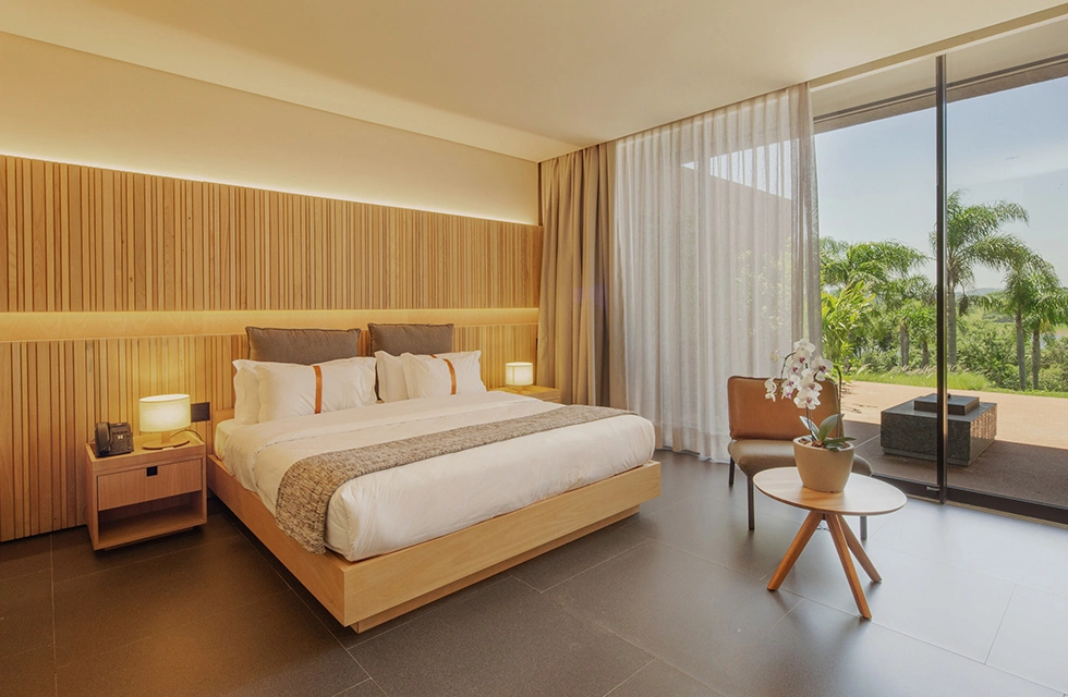 Quarto do Clara Ibiúna com painel de madeira ripada e vista para a represa de Itupararanga