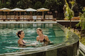 Piscina de borda infinita do Clara Arte cercada por natureza, com hóspedes aproveitando o entardecer em Brumadinho